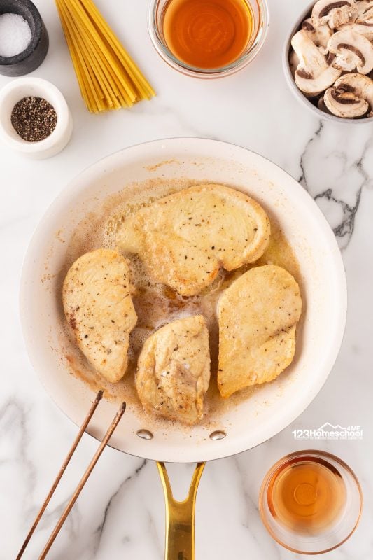 In a large skillet: melt butter in oil over medium heat, place chicken and lightly brown on both sides.