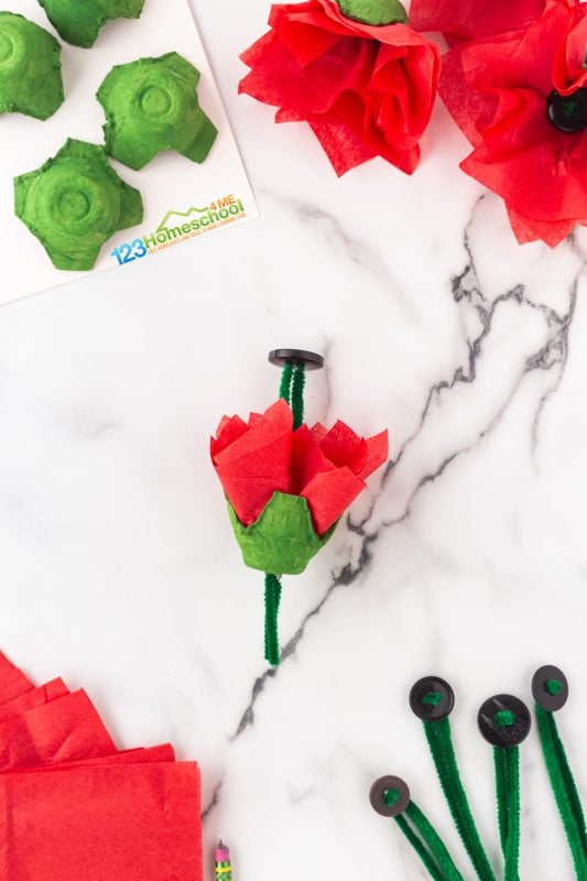 To make your project easier, you can either use a pencil to poke a pilot hole through the egg carton or simply press a prepared pipe cleaner through the tissue paper and into the carton.