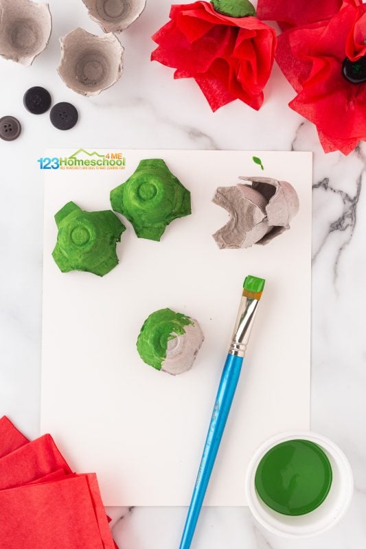 Start your project by carefully separating the egg carton into individual holders. Flip it upside down and add a touch of nature by painting the outside a vibrant mountain green. Once you're done, set it aside and let it dry. 