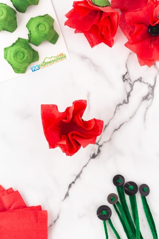 Start by stacking 3-4 squares of tissue paper. Gently press the center of the stack into the middle of a fully dried, painted egg carton. 