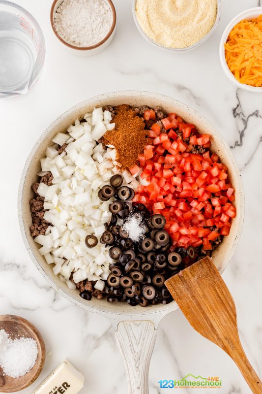 Next up, stir in 2 cups of chopped onions, a 28 oz can of diced tomatoes, 1 cup of sliced black olives, 2 tablespoons of chili powder, and 1 1/2 teaspoons of salt. Enjoy the delicious aromas as everything comes together! Best Recipe for Tamale Pie