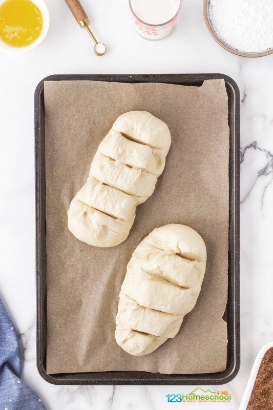 form 2 loaves and slit the top Preheat your oven to 350°F! Grab two 9x5-inch loaf pans and line them with parchment paper, letting it hang over the sides for easy removal. If you prefer, feel free to go with the easy route and use disposable foil pans like Dolly does! Don't forget to make four deep slashes across the top of each loaf – this allows the dough to expand beautifully while baking.