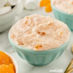 Looking for a quick, easy side dish? Try this delicious orange jello salad with pineapple, mandarin oranges, marshmallows, and cool whip - Yum!