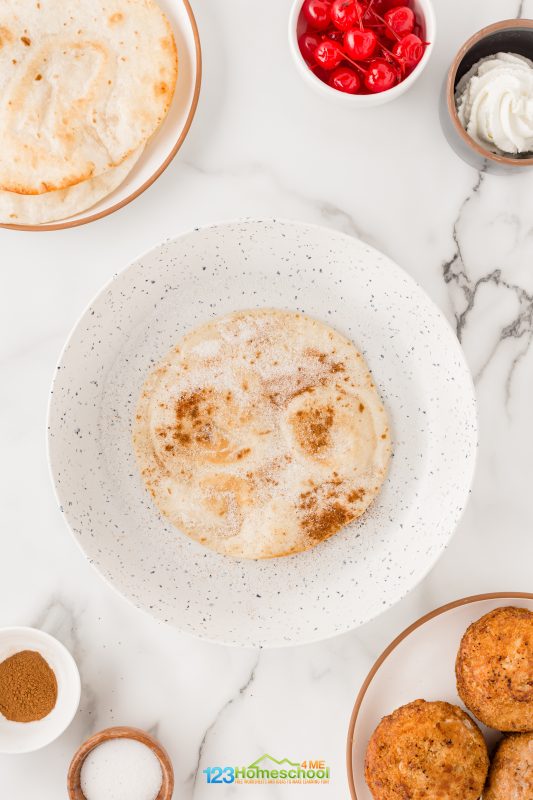 Remove and put on top of cinnamon and sugar mixture aggitating carefully back and forth to affix the coating; turn and repeat. Now set the tortilla on a plate. Repeat with the other flour tortillas.