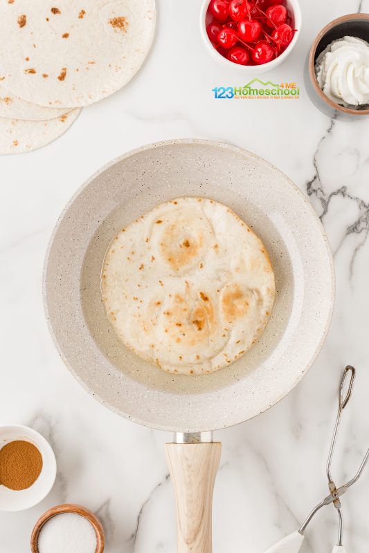 Using tongues, place a flour tortilla in the hot oil for 45-60 seconds on each side. fry tortilla shells