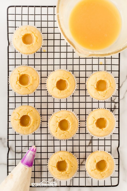 fill cupcakes with carmelized white chocolate Start by making a small cavity in the center of each cupcake—just deep enough but not piercing the bottom. Next, fill that delightful little hole with a generous spoonful of the caramelized white chocolate mixture (about 1 tablespoon per cupcake).
