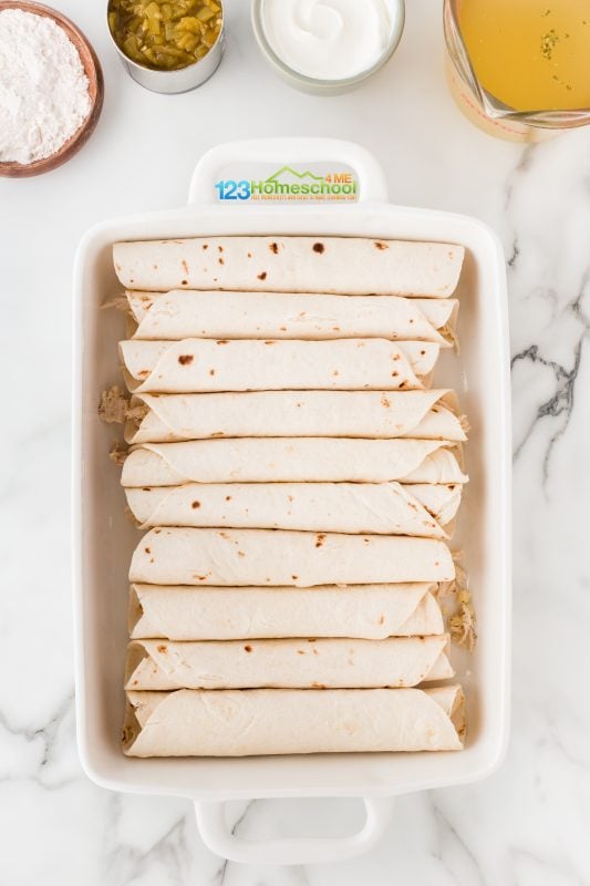 place rolled flour tortillas in 9x13 pan Carefully roll up those delicious chicken-filled tortillas and arrange them in the prepared baking dish!