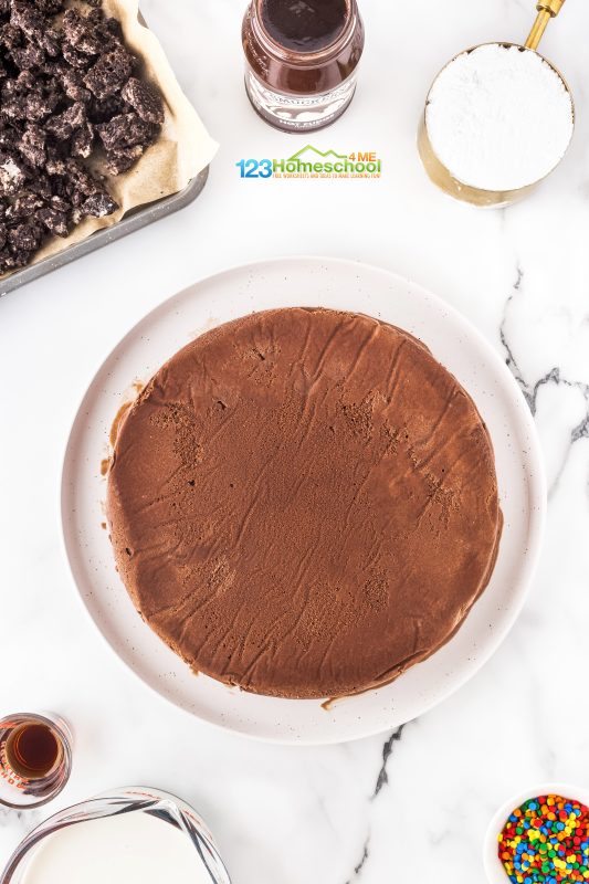 Once everything is frozen solid, it’s time to assemble your dessert masterpiece! Start by flipping the bottom layer onto a large plate. Next, sprinkle and press cookie pieces on top until it’s fully covered. Drizzle a jar of your favorite (unheated) hot fudge sauce over the cookies. Now, flip the other layer of ice cream on top of the fudge for that perfect combination. Cover it up and pop it back in the freezer for another 30-60 minutes. Once everything is frozen solid, it’s time to assemble your dessert masterpiece! Start by flipping the bottom layer onto a large plate. Next, sprinkle and press cookie pieces on top until it’s fully covered. Drizzle a jar of your favorite (unheated) hot fudge sauce over the cookies. Now, flip the other layer of ice cream on top of the fudge for that perfect combination. Cover it up and pop it back in the freezer for another 30-60 minutes.