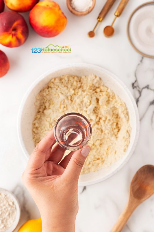 add chilled water Fill a cup with ice and cold water and give it a minute to chill.
Slowly pour in 1/2 cup of the cold water into the flour mixture while stirring. Continue to add water gradually until the dough comes together easily, forming large clumps.